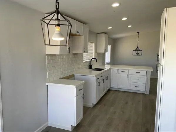 a kitchen with appliances a sink and cabinets