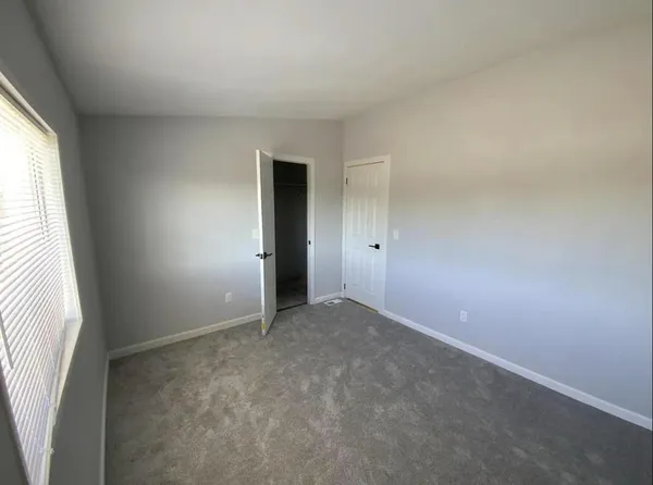 an empty room with windows and closet