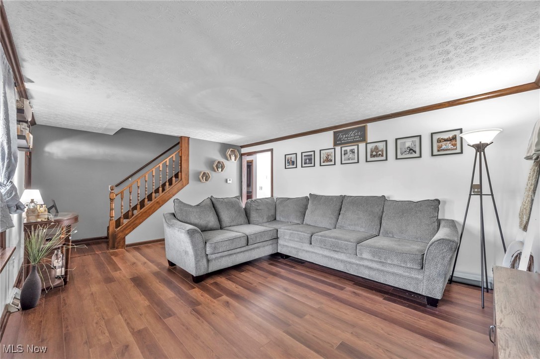 9827 Akron Road Rittman, OH 44270 - Photo 8 of 47 Living room with a textured ceiling, stairway, wood finished floors, and ornamental molding