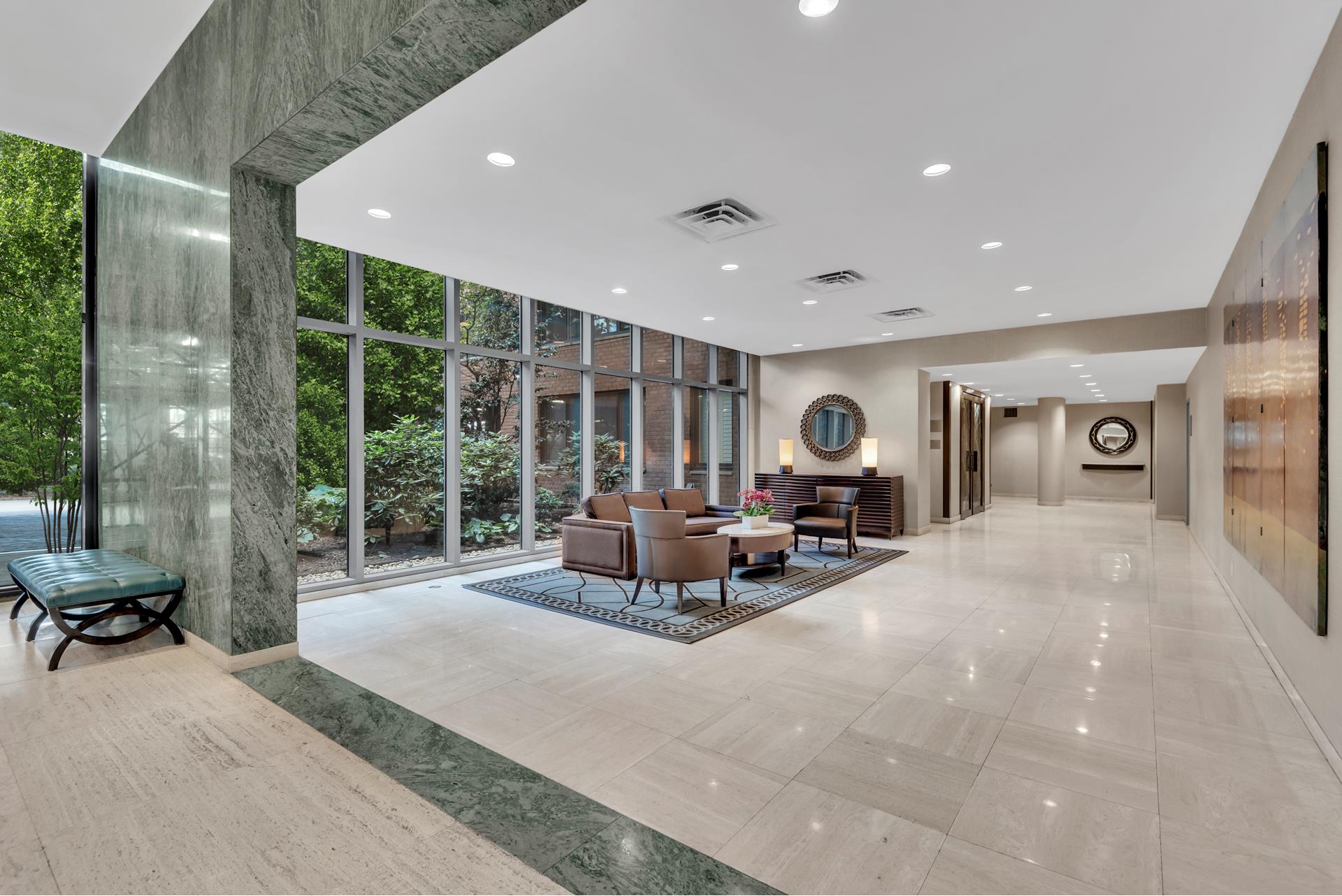 60 Sutton Place South, Unit 11FN Manhattan, NY 10022 - Photo 6 of 10 a living room with furniture and large windows