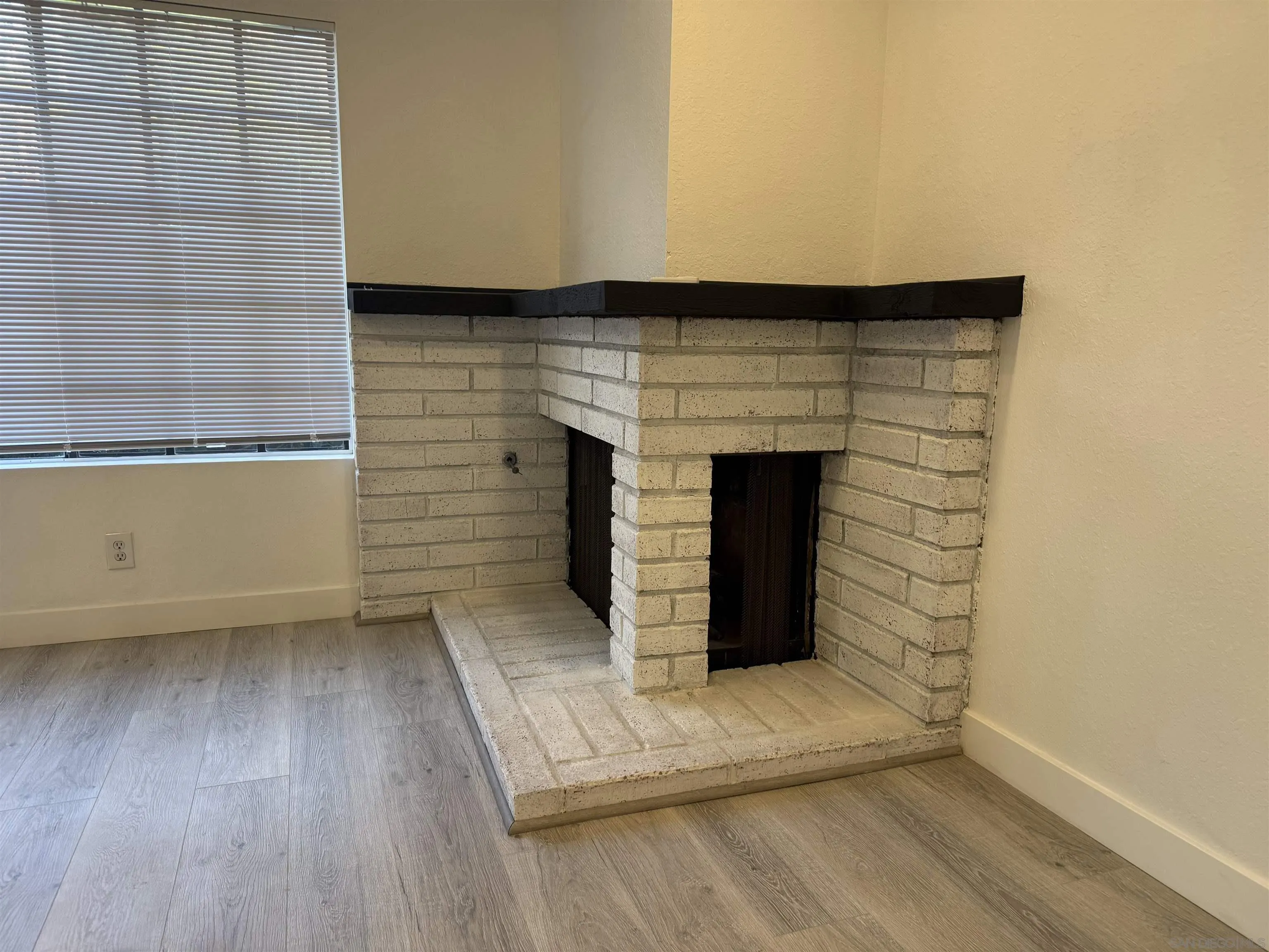 8868 Regents Road, Unit 103 San Diego, CA 92122 - Photo 14 of 50 an empty room with wooden floor and fireplace