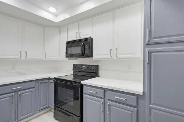 a kitchen with granite countertop white cabinets and black appliances