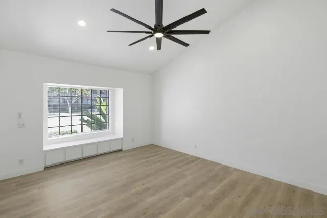 an empty room with a window and a fan