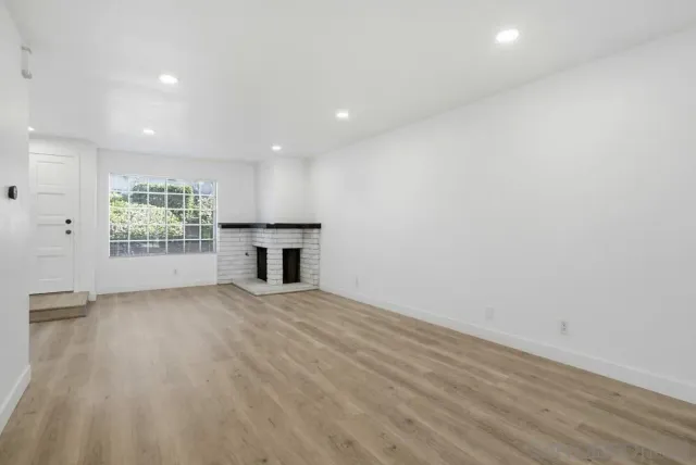 an empty room with windows and fireplace