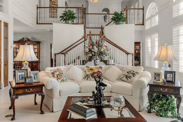 a living room with furniture a chandelier and a large window