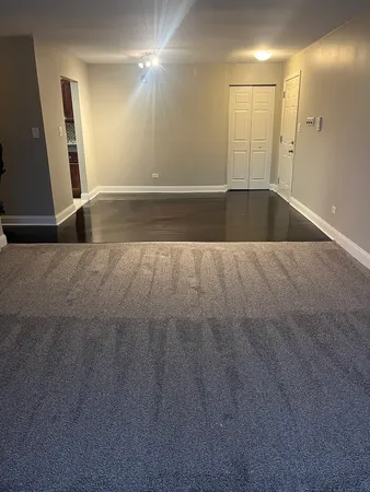 an empty room with wooden floor and mirror