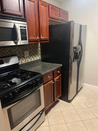 a kitchen with granite countertop a stove and a refrigerator