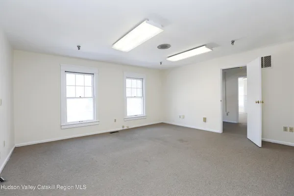 an empty room with windows and closet