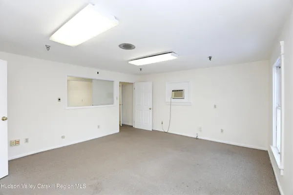 an empty room with white walls and windows