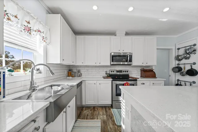 a kitchen with stainless steel appliances granite countertop a sink stove microwave and refrigerator