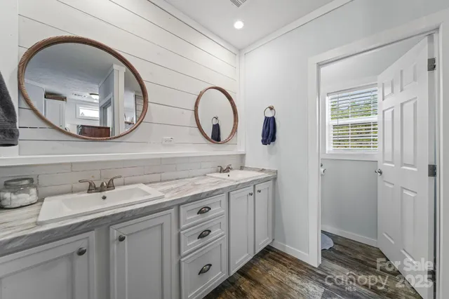 a bathroom with a granite countertop double vanity sink and a mirror