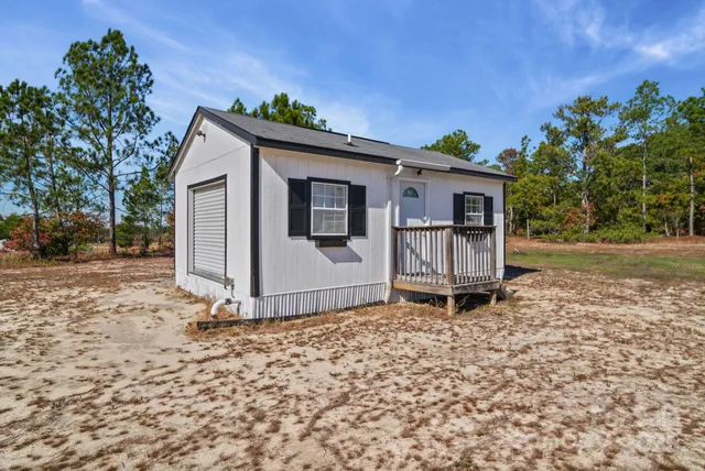 a backyard of a house with wooden fence and large trees