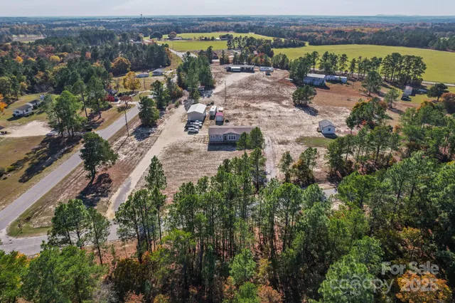 an aerial view of a house with a yard and lake view