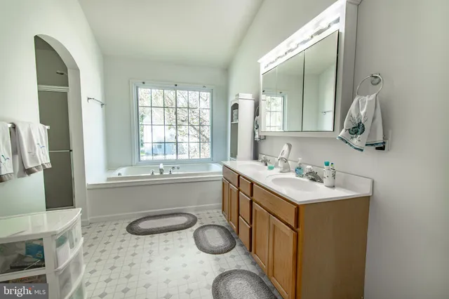 a bathroom with a tub sink and mirror