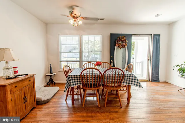 a view of a a dining room with furniture window and wooden floor