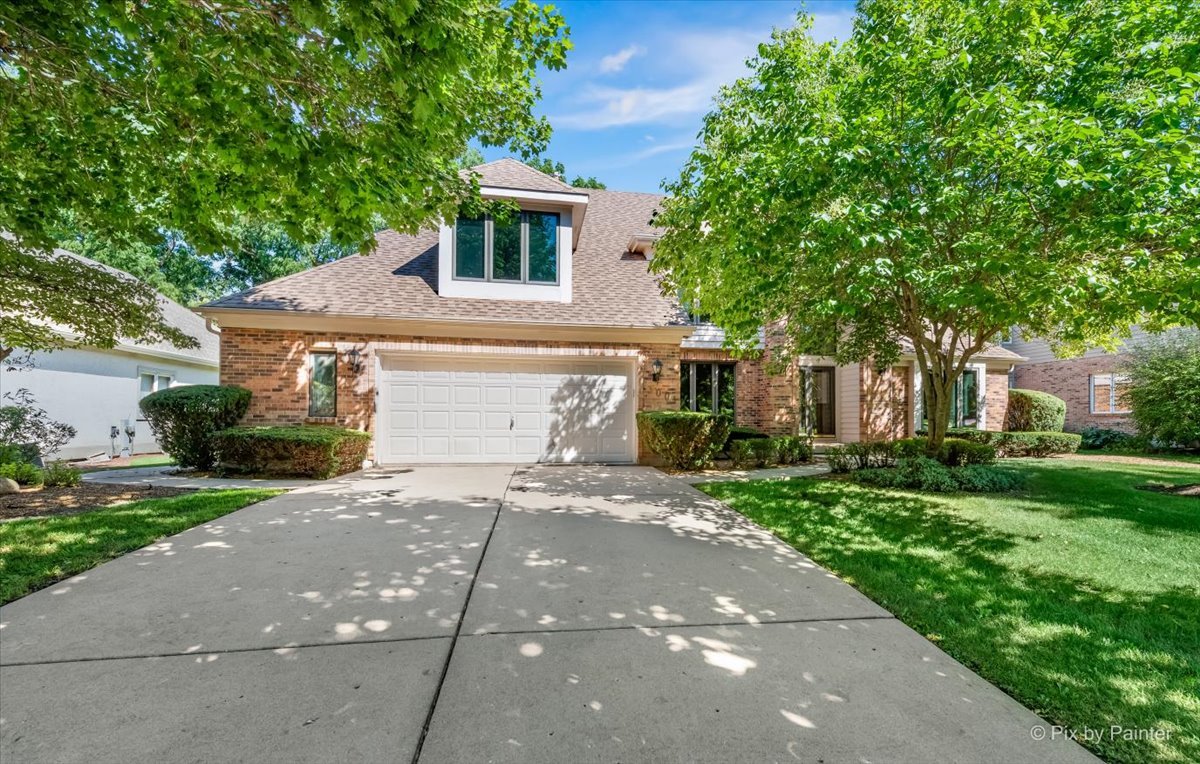 a front view of a house with a yard and a garage