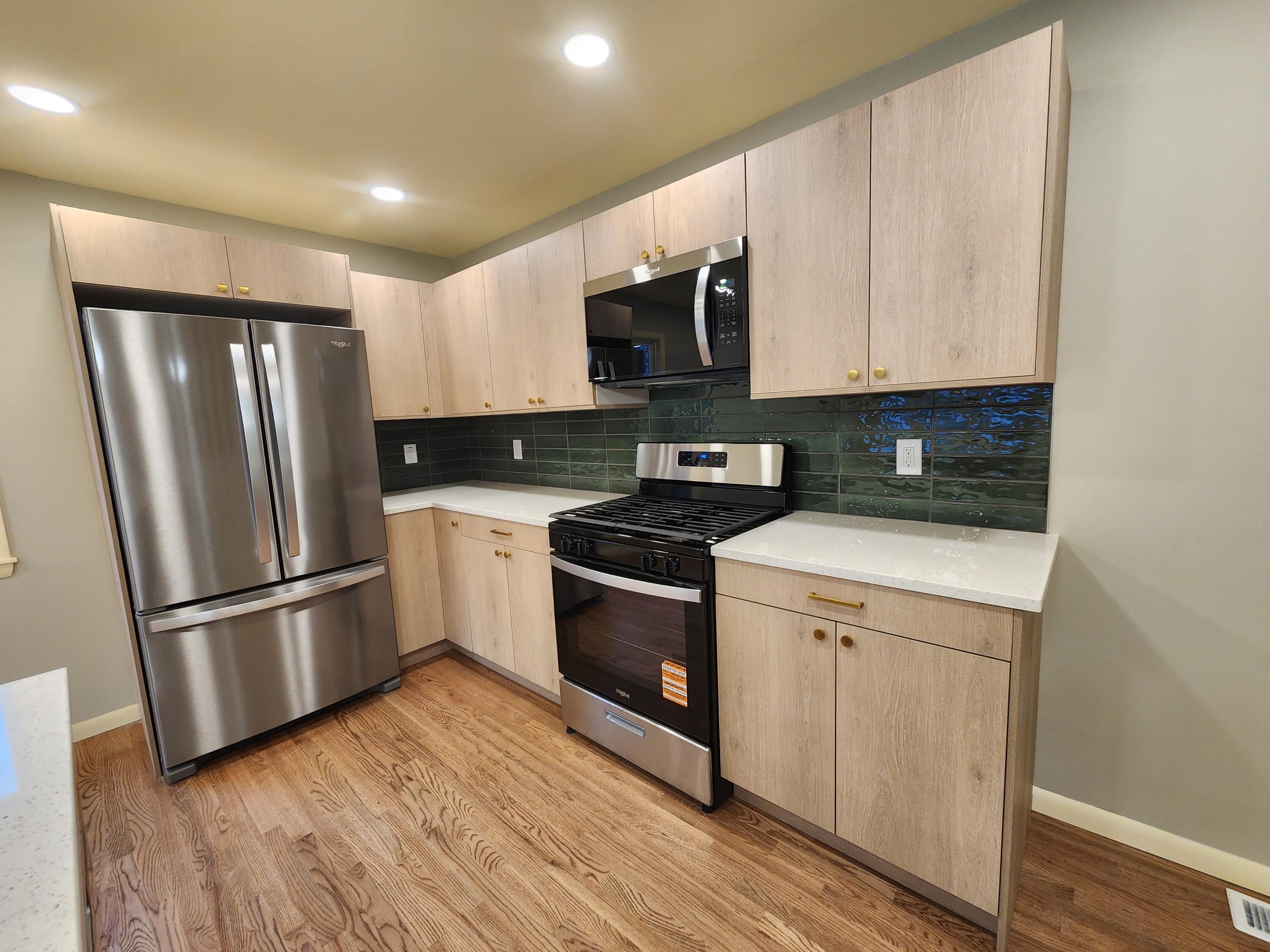 5049 Indiana Place Gary, IN 46409 - Photo 11 of 24 a kitchen with a refrigerator stove and wooden cabinets