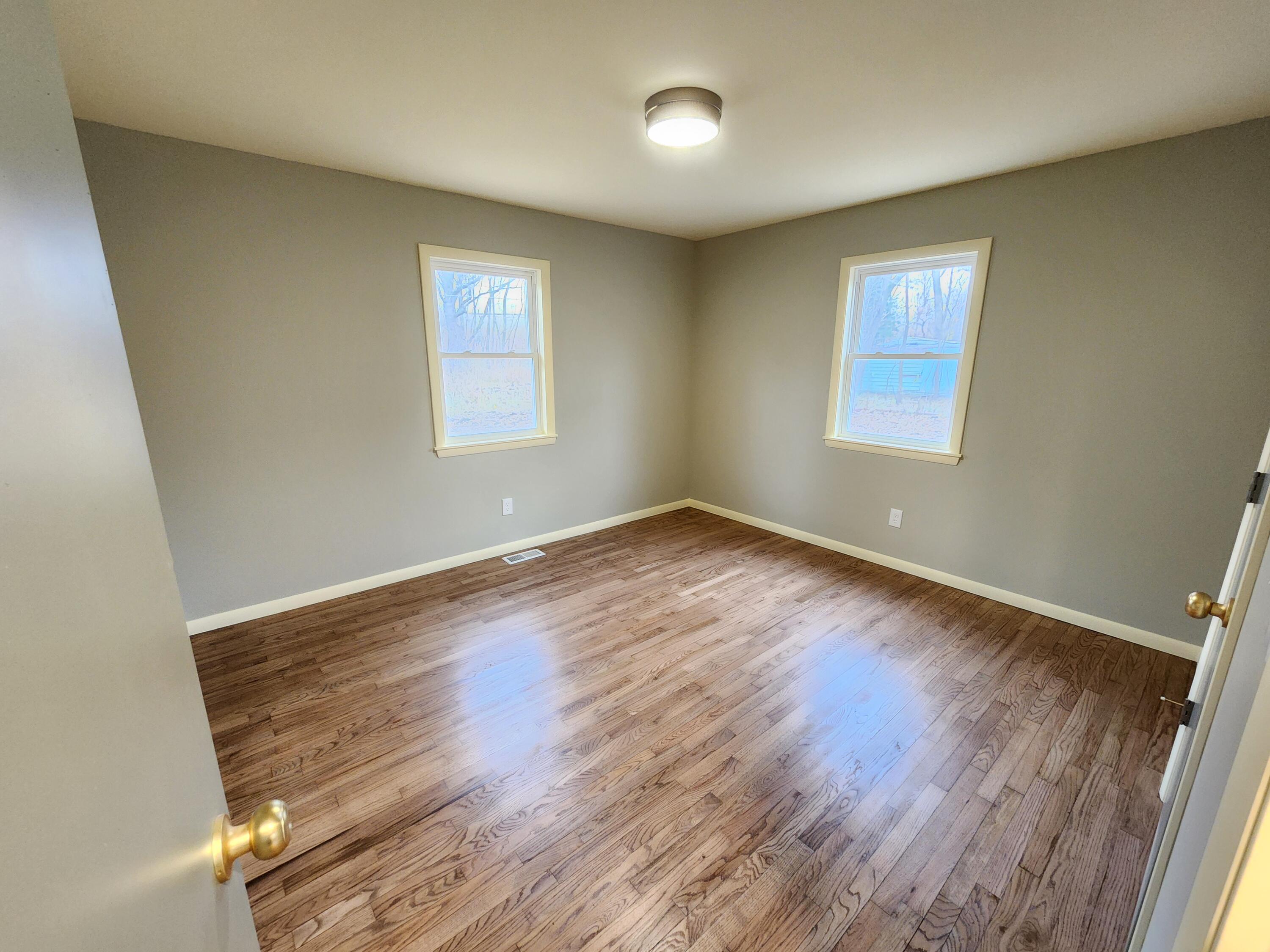 5049 Indiana Place Gary, IN 46409 - Photo 13 of 24 an empty room with wooden floor and windows
