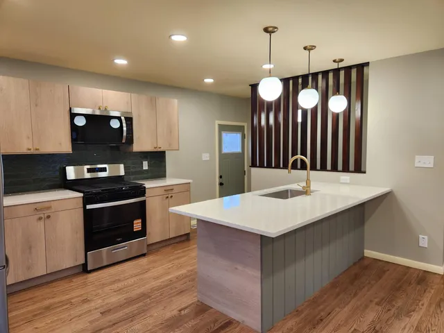 a kitchen with a refrigerator stove and wooden cabinets
