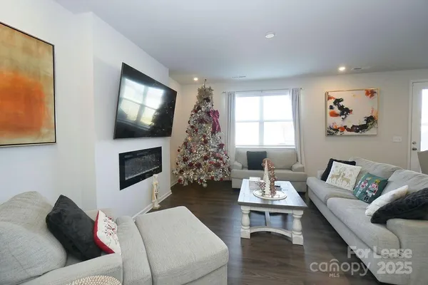 a living room with furniture a flat screen tv and a window