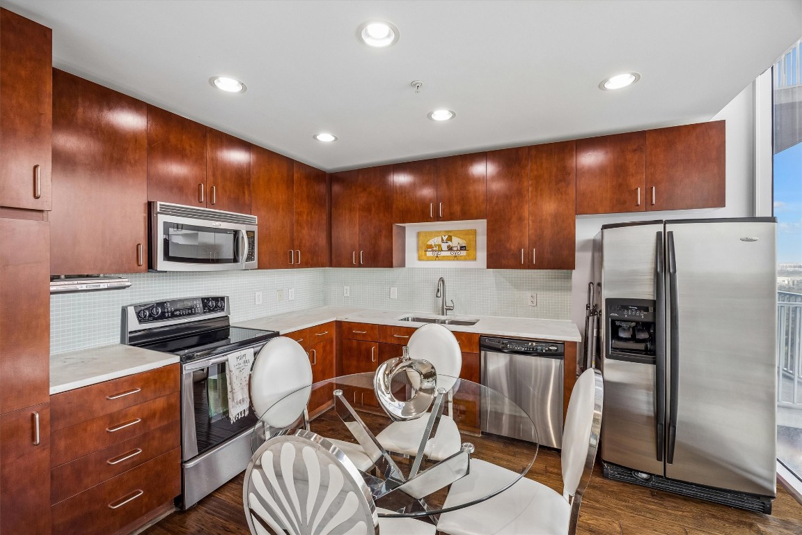 5925 Almeda Road, Unit 11907 Houston, TX 77004 - Photo 9 of 35 a kitchen with stainless steel appliances granite countertop a refrigerator and a stove top oven with wooden floor