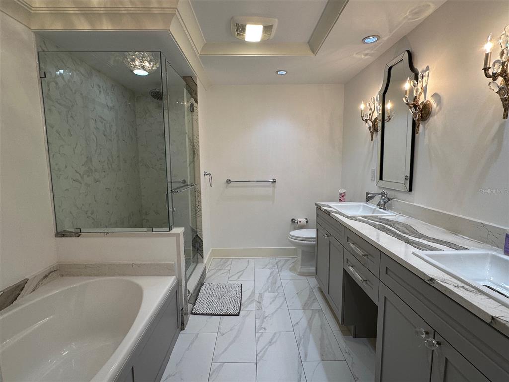 1350 Main Street, Unit 1401 Sarasota, FL 34236 - Photo 22 of 69 a bathroom with a granite countertop sink a toilet and shower