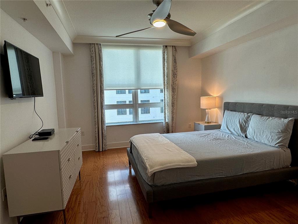 1350 Main Street, Unit 1401 Sarasota, FL 34236 - Photo 28 of 69 a bedroom with a bed a window and a chandelier