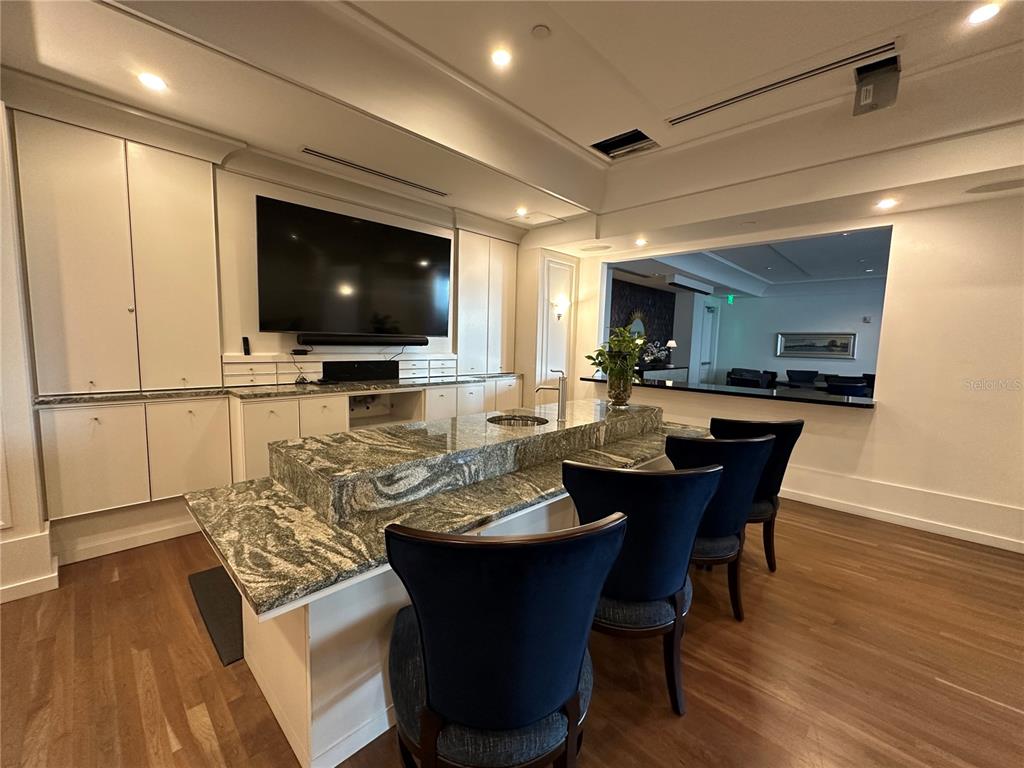 1350 Main Street, Unit 1401 Sarasota, FL 34236 - Photo 57 of 69 a view of a dining room with furniture wooden floor and a flat screen tv