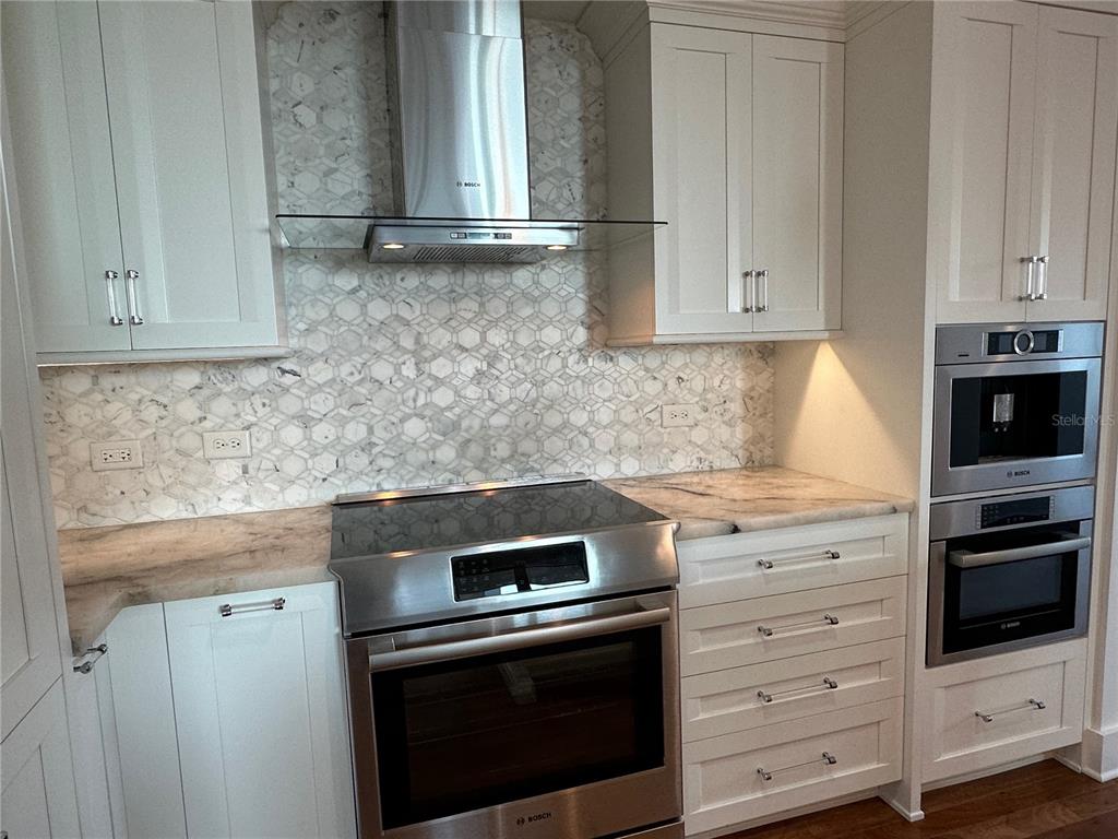 1350 Main Street, Unit 1401 Sarasota, FL 34236 - Photo 8 of 69 a kitchen with granite countertop white cabinets and stainless steel appliances