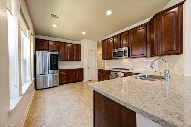 a view of kitchen and kitchen with granite countertop cabinets