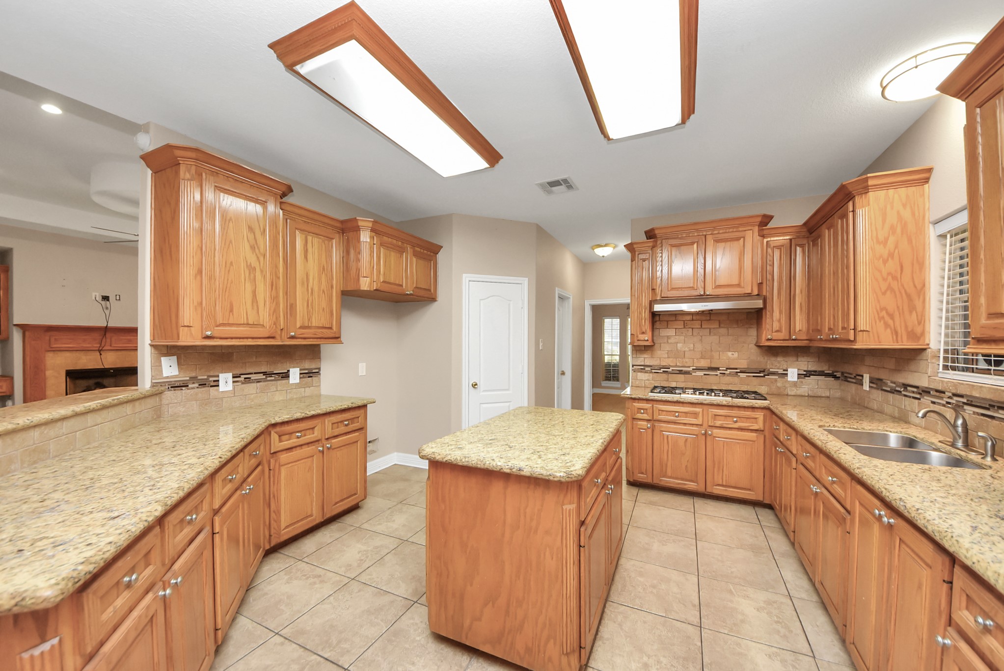 4320 Barkaloo Road Baytown, TX 77521 - Photo 22 of 28 a large kitchen with stainless steel appliances granite countertop a sink stove refrigerator granite counter tops and a view of living room
