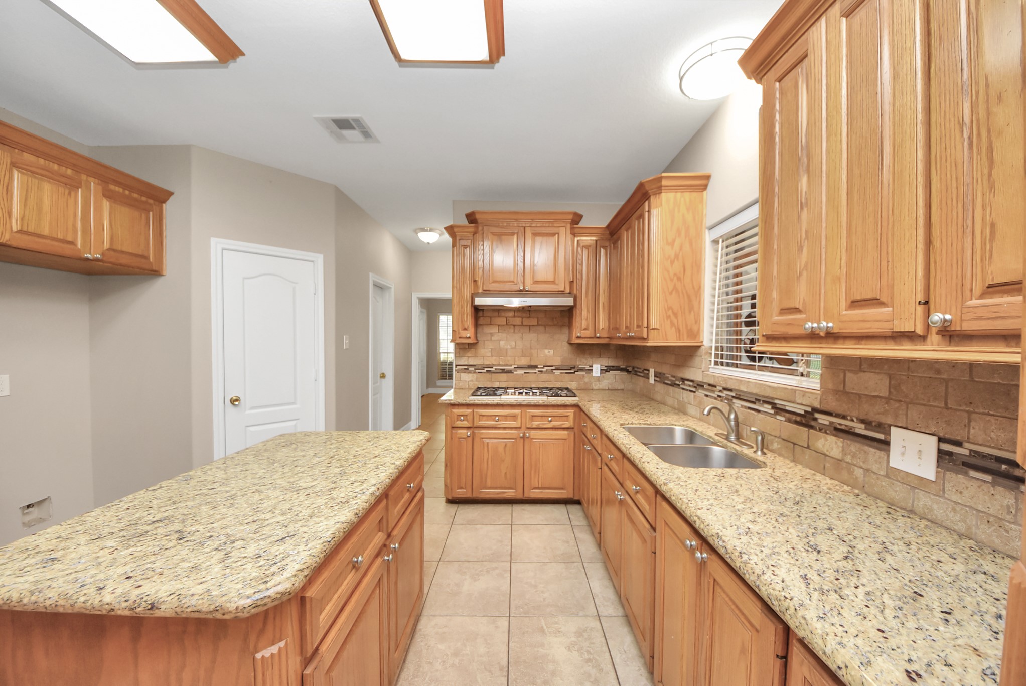 4320 Barkaloo Road Baytown, TX 77521 - Photo 23 of 28 a kitchen with a stove a sink and a wooden cabinets