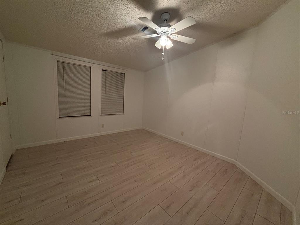 1622 Southwest 35th Circle Okeechobee, FL 34974 - Photo 16 of 19 an empty room with wooden floor and windows