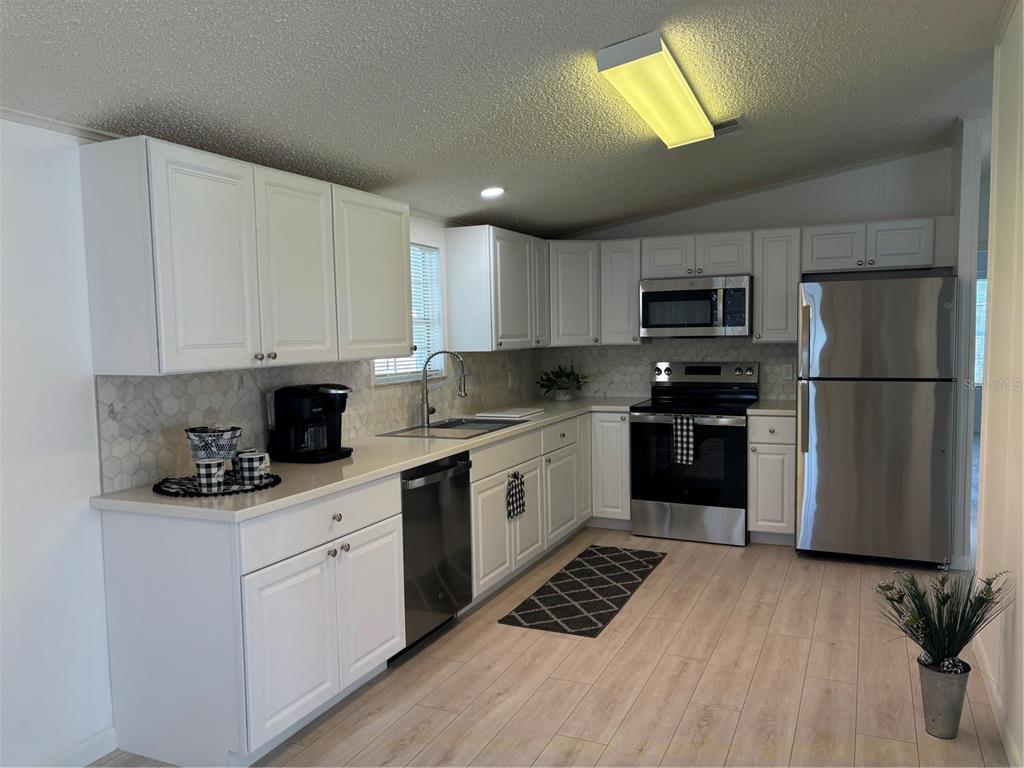 1622 Southwest 35th Circle Okeechobee, FL 34974 - Photo 2 of 19 a kitchen with kitchen island granite countertop stainless steel appliances cabinets a sink and a counter top space