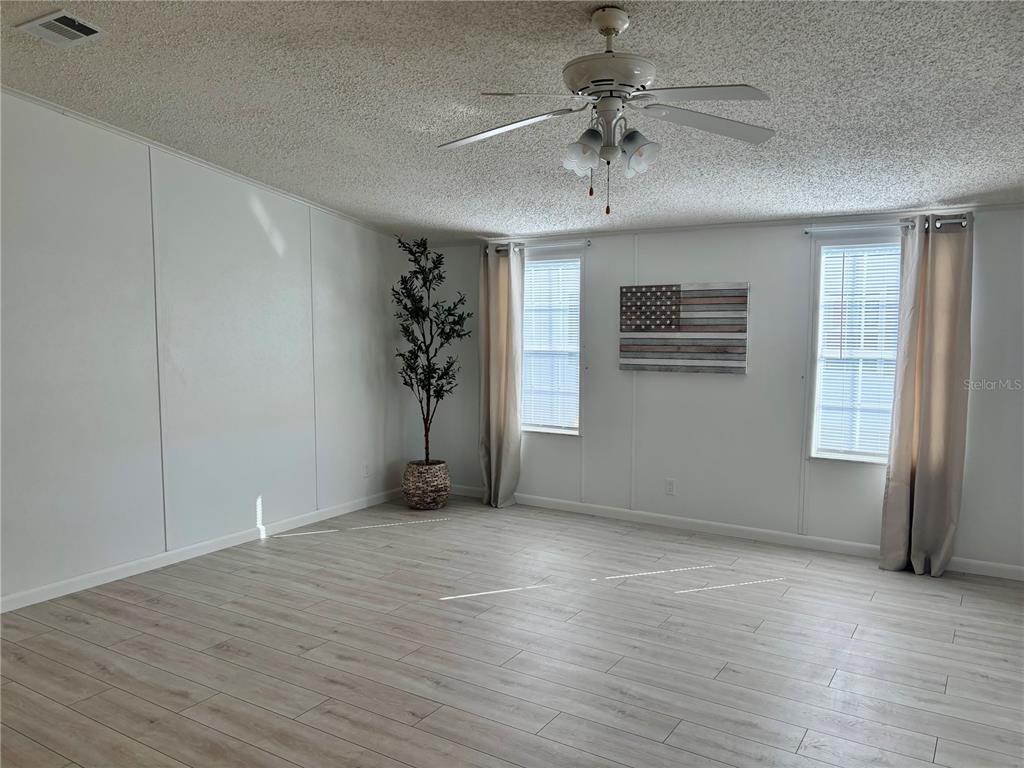 1622 Southwest 35th Circle Okeechobee, FL 34974 - Photo 5 of 19 wooden floor in an empty room with a window