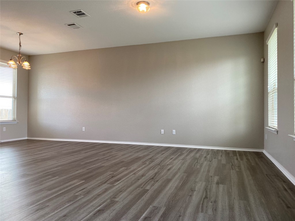 304 Azurite Drive Jarrell, TX 76537 - Photo 14 of 24 Unfurnished room featuring dark wood-type flooring and a chandelier