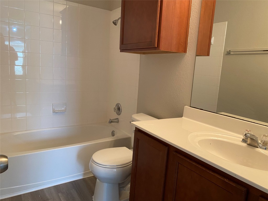 304 Azurite Drive Jarrell, TX 76537 - Photo 20 of 24 Full bath featuring vanity, shower / tub combination, dark wood-style flooring, and a textured wall