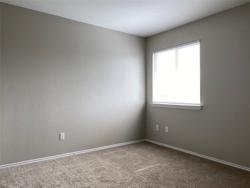 304 Azurite Drive Jarrell, TX 76537 - Photo 4 of 24 Spare room with carpet flooring and a textured wall