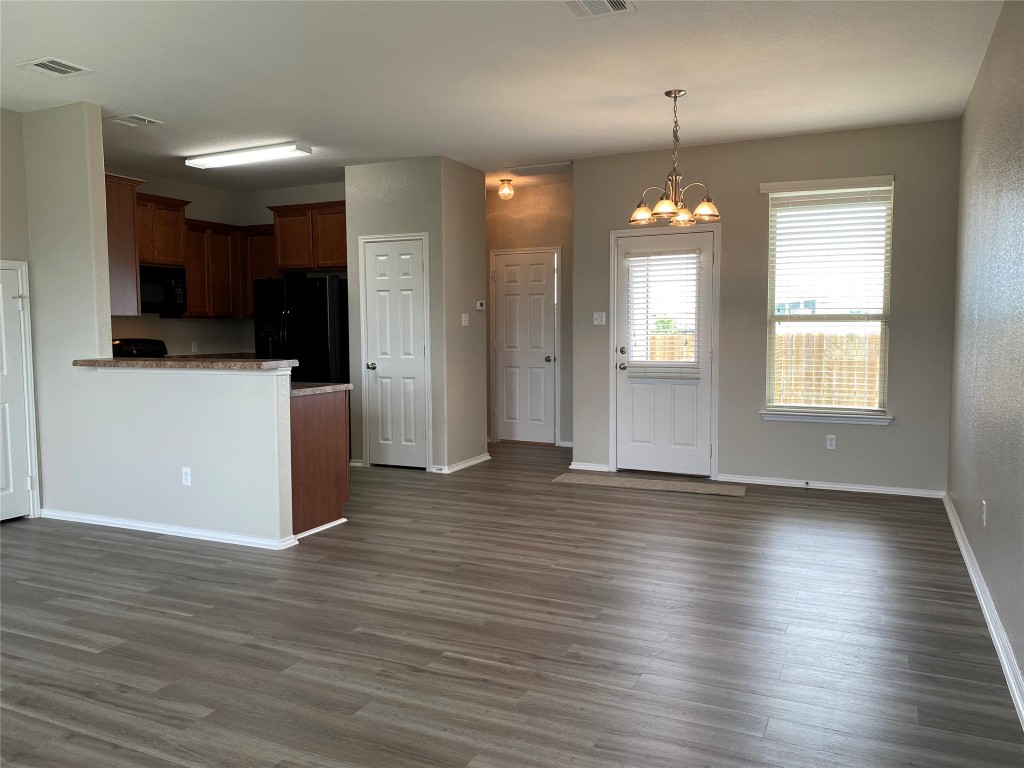 304 Azurite Drive Jarrell, TX 76537 - Photo 24 of 24 Kitchen featuring a chandelier, hanging light fixtures, open floor plan, and black appliances