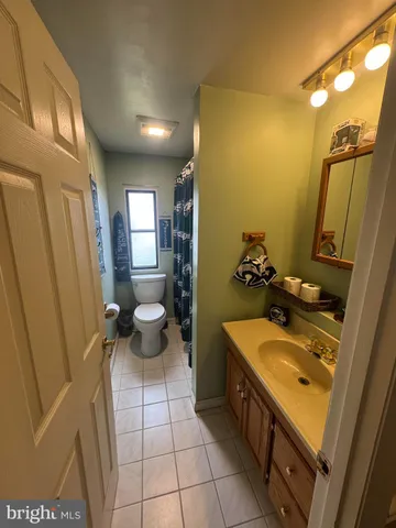 a large bathroom with a sink a toilet a mirror and shower