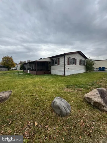 a view of a house with yard and sitting area