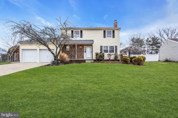 a front view of a house with a yard and trees