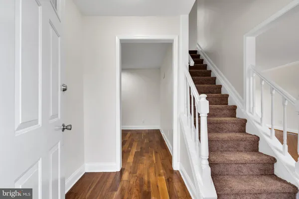 a view of a hallway with wooden floor and entryway
