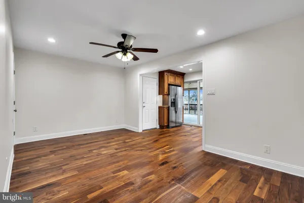 a view of empty room with wooden floor and ceiling fan