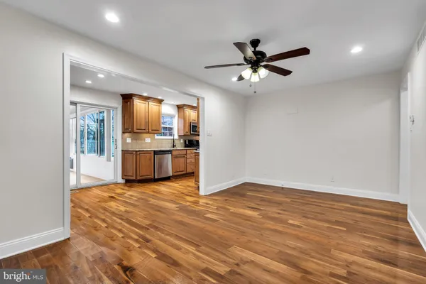 a view of a kitchen with a ceiling fan hardwood floor and a kitchen counter top space