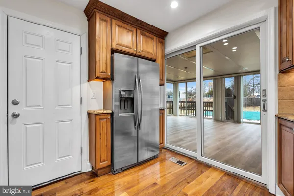 a view of a refrigerator in kitchen and an empty room