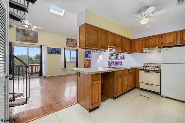 a kitchen with stainless steel appliances granite countertop a refrigerator a stove and a sink