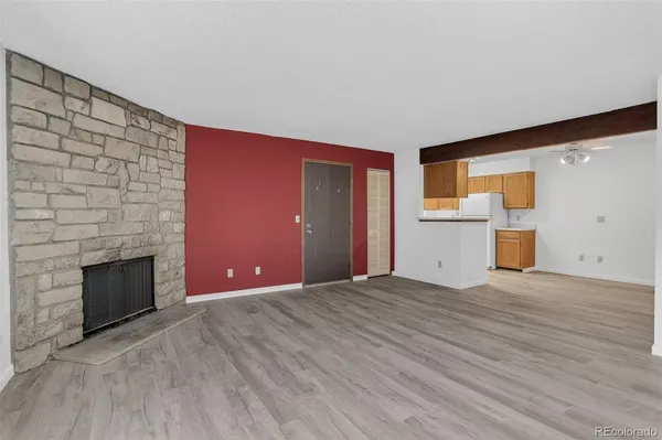a view of empty room with a fireplace and wooden floor