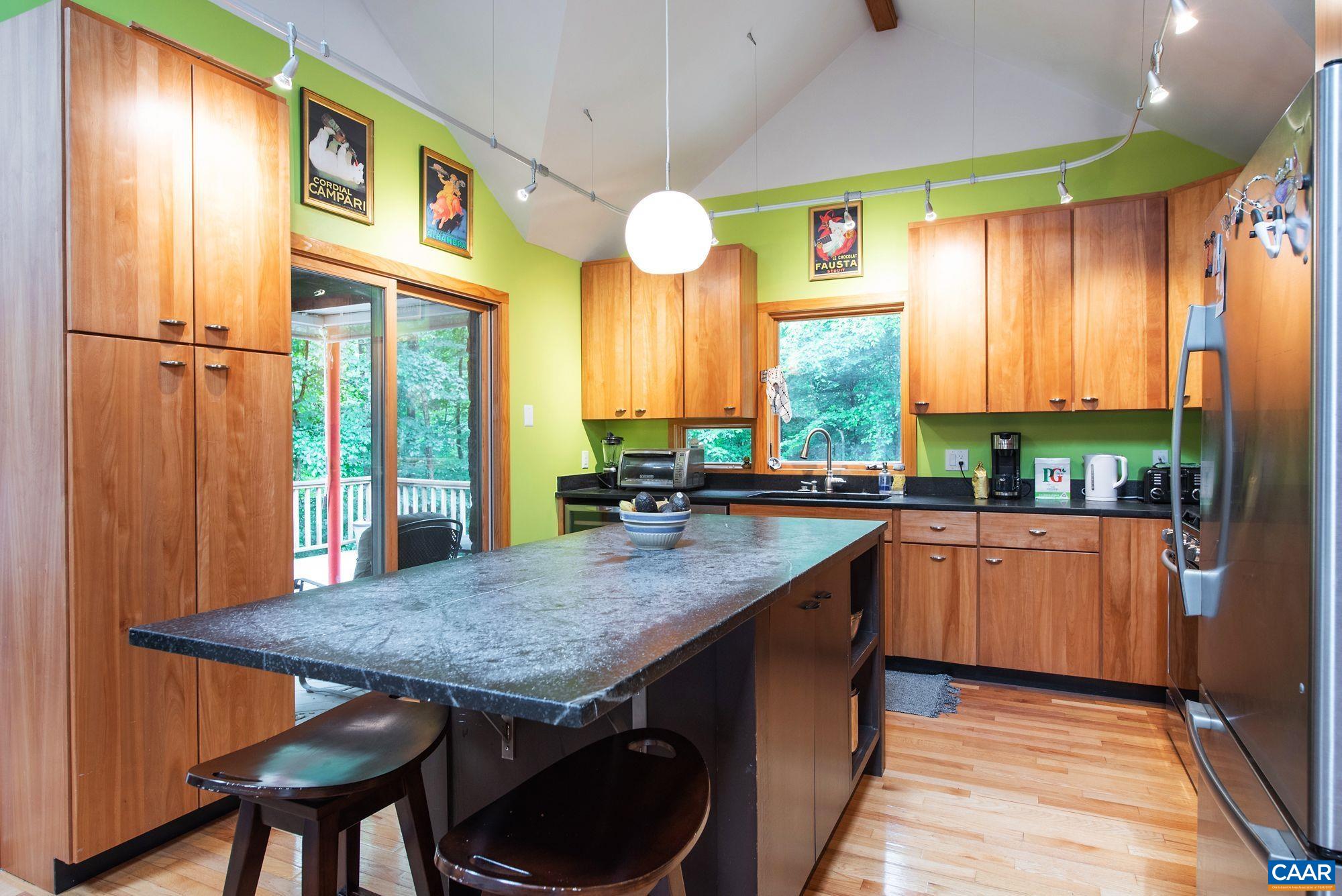 1091 Tilman Road Charlottesville, VA 22901 - Photo 5 of 17 a kitchen with stainless steel appliances granite countertop wooden cabinets a dining table and chairs