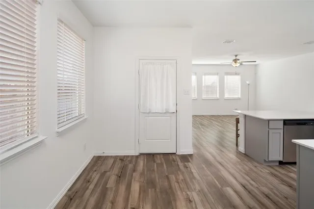 a view of a kitchen with wooden floor and a window